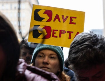 the face of a protester with a sign reading SAVE SEPTA