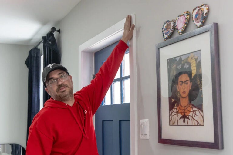 A man checks for air leakages at a home's door