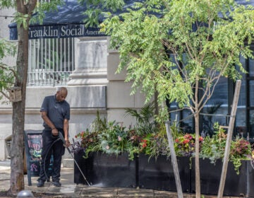 A man power washing the sidewalk
