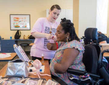 Rebecca Carpino (left) helps Candice Davis (right) align a makeup brush