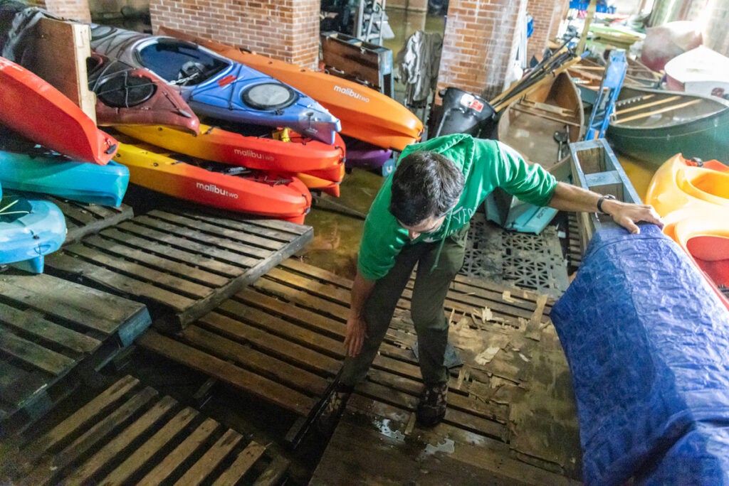 Adam Forbes demonstrates how high flood waters rose at the FDR Park Boathous