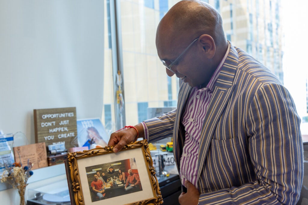 Veenu Aishwarya holding a photo of his staff