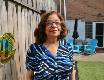 Denise Statham stands in the backyard of her frequently flooded home in Eastwick. (Emma Lee/WHYY)
