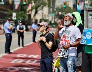 Striking Philadelphia municipal workers carry signs and chant during Philadelphia's Fourth of July parade.