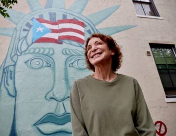 Jane Golden poses in front of her first murals