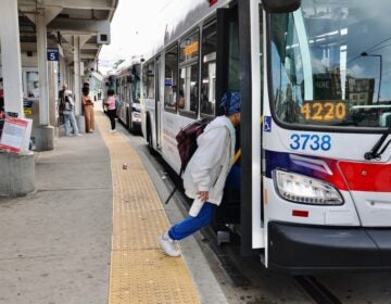 A woman steps onto a bus
