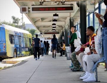 Many people waiting in the outdoor bus terminal