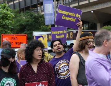 People holding up signs as they gather at the protest