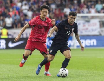 Two soccer players fight for the ball