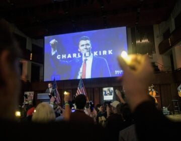 People hold candles and sing during a memorial and prayer vigil for Charlie Kirk at the John F. Kennedy Memorial Center for the Performing Arts, Sunday, Sept. 14, 2025, in Washington. (AP Photo/Rod Lamkey, Jr.)