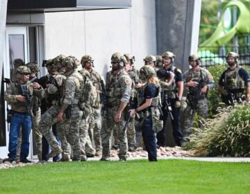 Law enforcement officials prepare to sweep a building