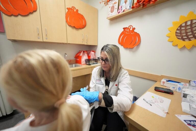 Pharmacy manager Aylen Amestoy administers a patient with a COVID-19 vaccine