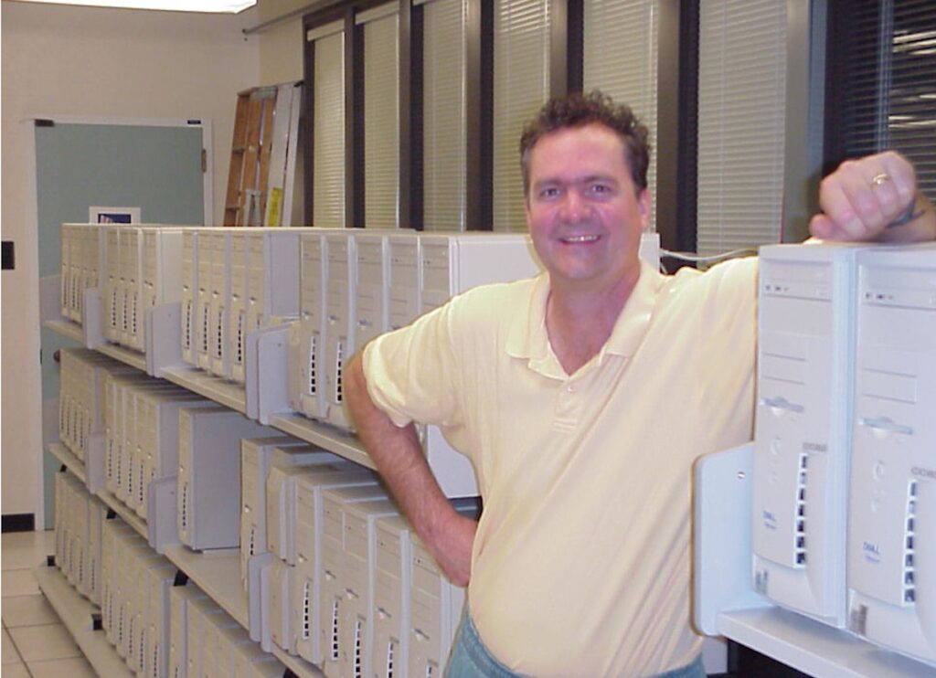 David Haussler, UC Santa Cruz biomolecular engineering professor, stands next to dell workstations his team linked together to create a makeshift supercomputer for the Human Genome Project. (Courtesy of David Haussler) 