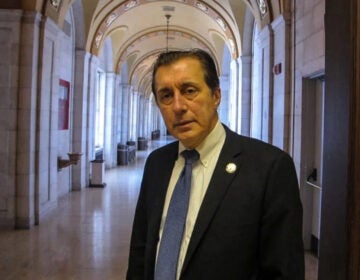 John Burzichelli looks on