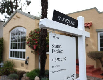 A for sale sign sits outside of a house