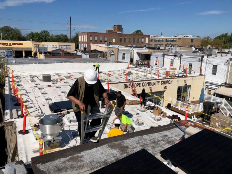 Solar installers set up an array on the roof of One Hope Community Church in Hunting Park.