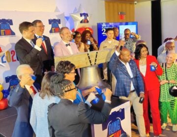 City officials celebrate in front of a replica of the Liberty Bell