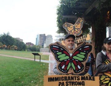 Immigrant advocates hold signs at a rally in Philadelphia