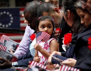 a yung girl waves a small American Flag during the ceremony