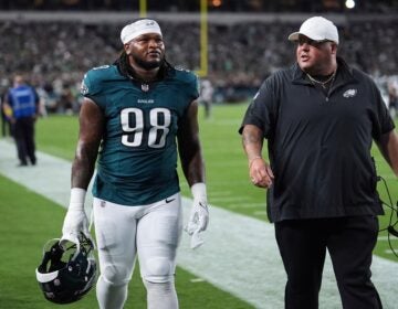 Jalen Carter walks alongside Big Dom on the Eagles sideline