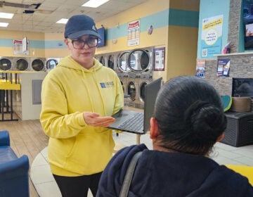Outreach worker Mariela Tentsoglides speaking to woman at laundromat about healthcare