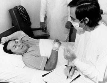 Dr. Stephen Thacker, right, of the U.S. Center for Disease Control, interviews Thomas Payne in Chambersburg Hospital in Pennsylvania, Aug. 4, 1976. Payne was one of the Legionnaires who became ill after attending a state convention in Philadelphia.  (AP Photo/Pool)
