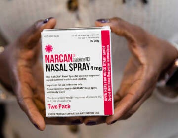A person holds a box of Narcan spray