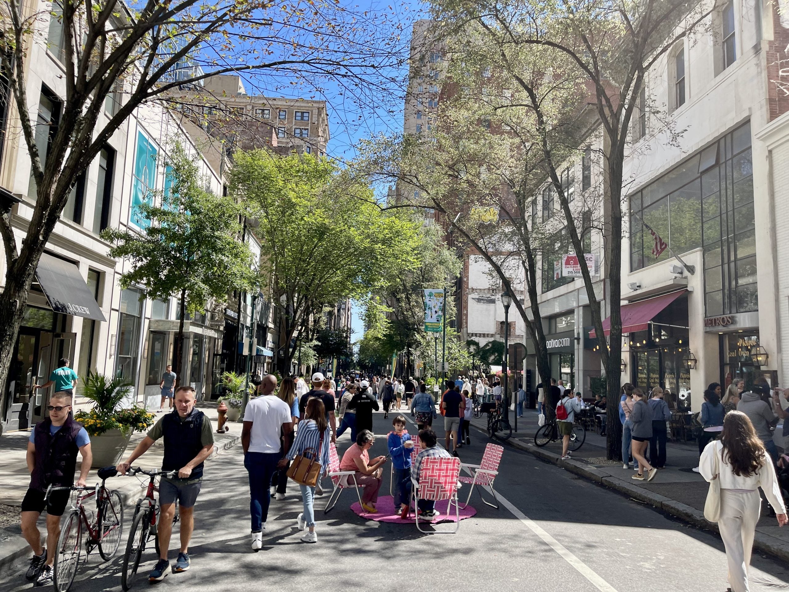 Lots of people walking around on a closed busy street