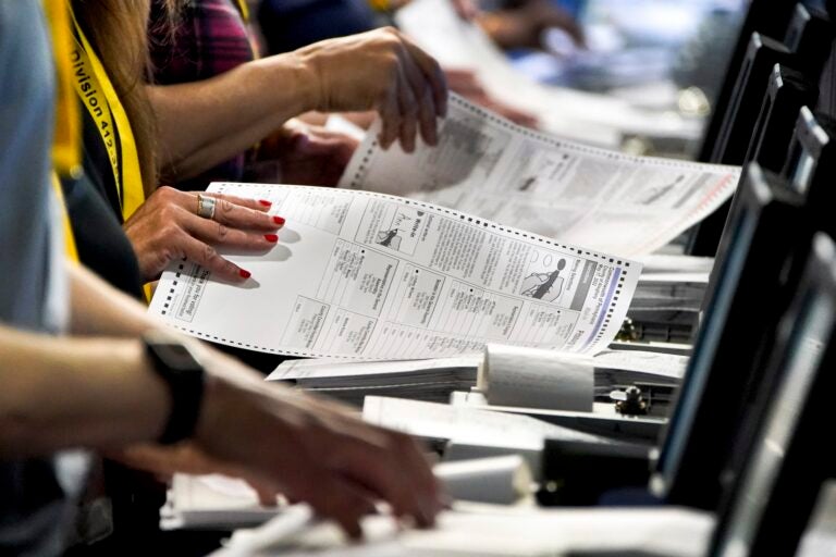 Election workers perform a recount of ballots