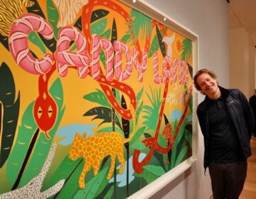 Joel Mesler stands beside his 2023 screenprint, ''Candy Land