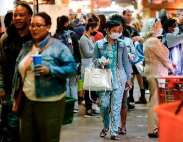 Customers, some wearing face masks, patronize the Reading Terminal Market