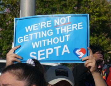 a sign reads WE'RE NOT GETTING THERE WITHOUT SEPTA