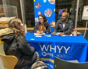 WHYY's pop-up newsroom at Princeton Public Library. Madhu Bora and P. Kenneth Burns speak with an attendee