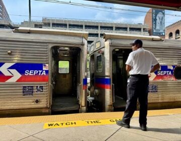 A SEPTA employee monitors trains at a regional rail platform