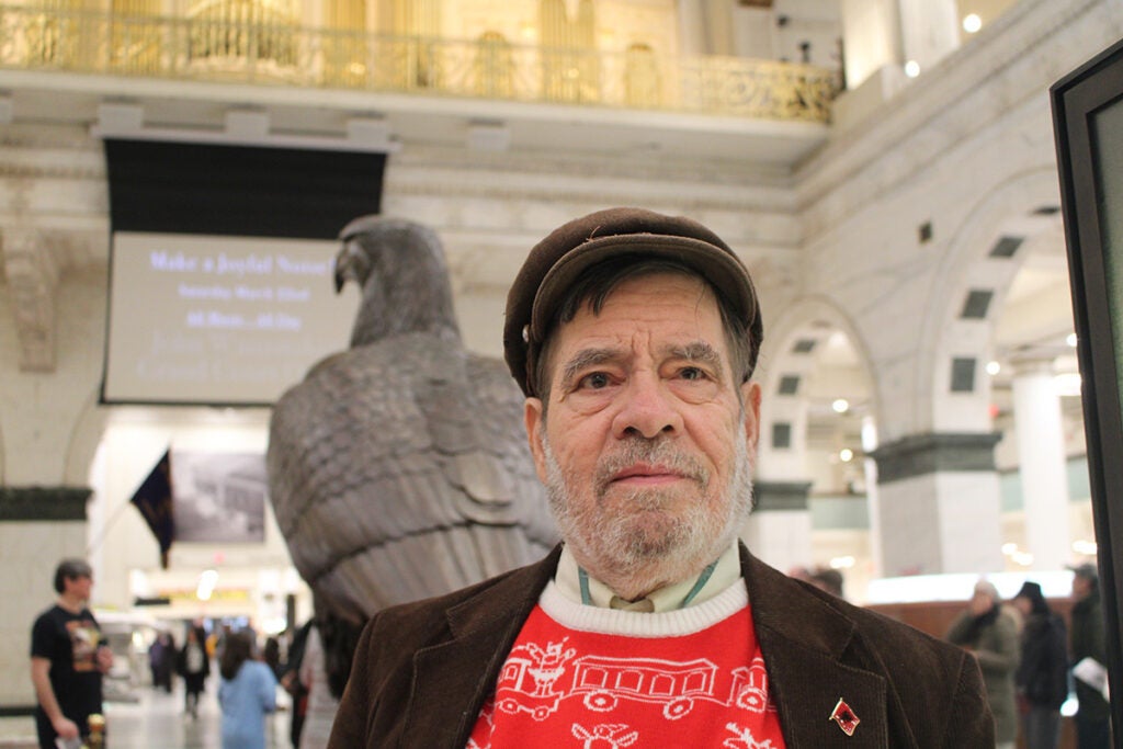 A man stands in front of a statue of an Eagle